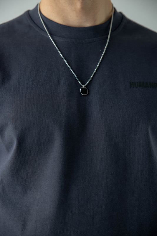 Whether worn as a statement piece for formal occasions or as a subtle accent to everyday attire, this men's silver necklace with a black pendant exudes confidence and sophistication. It serves as a timeless symbol of refined masculinity, destined to become a cherished accessory that effortlessly complements the discerning gentleman's style.
