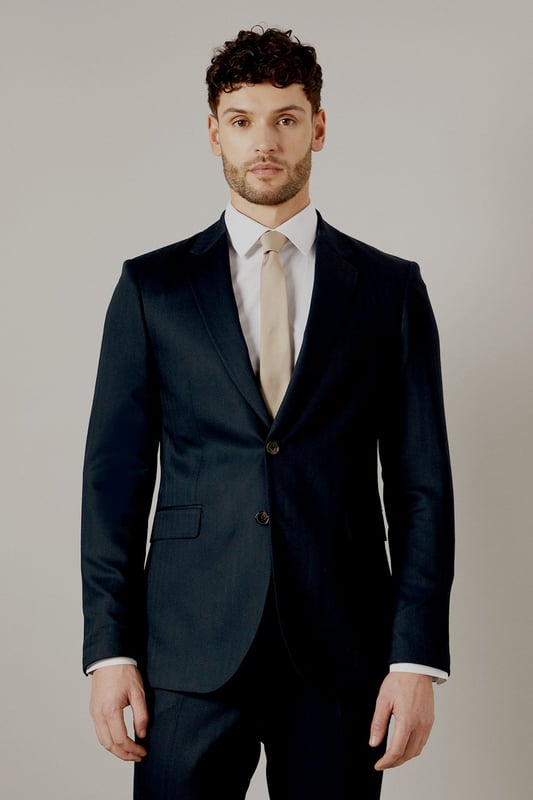 Tailored fit for a refined silhouette
        Distinctive herringbone pattern adds texture
        Notched lapels for classic sophistication
        Two-button front closure for versatile styling
        Flap pockets and a chest welt pocket for functionality
    
    This Burton herringbone suit jacket is the epitome of smart, sophisticated style. The tailored fit sculpts your silhouette while offering ease of movement, perfect for the modern gent who appreciates classic design with a contemporary edge. Ideal for a range of occasions, from important business meetings to smart-casual events at the local pub. Pair with matching trousers and a crisp white shirt for a complete look, or dress it down with dark denim and a light jumper for a more relaxed ensemble. The versatile nature of this jacket makes it a staple for any wardrobe, easily transitioning from day to night. Whether you're heading to the office, attending a wedding, or meeting friends for a posh night out, this jacket will ensure you look polished and put-together.