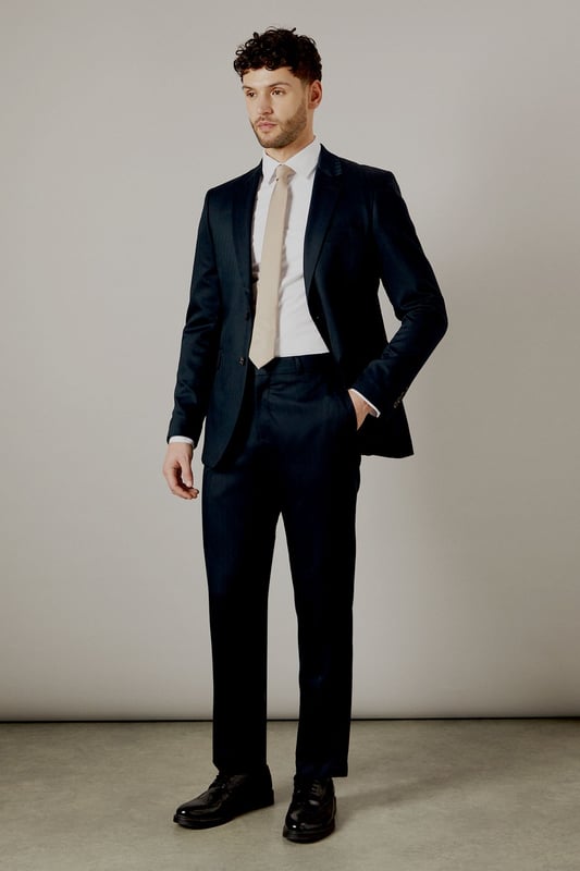 Tailored fit for a refined silhouette
        Distinctive herringbone pattern adds texture
        Notched lapels for classic sophistication
        Two-button front closure for versatile styling
        Flap pockets and a chest welt pocket for functionality
    
    This Burton herringbone suit jacket is the epitome of smart, sophisticated style. The tailored fit sculpts your silhouette while offering ease of movement, perfect for the modern gent who appreciates classic design with a contemporary edge. Ideal for a range of occasions, from important business meetings to smart-casual events at the local pub. Pair with matching trousers and a crisp white shirt for a complete look, or dress it down with dark denim and a light jumper for a more relaxed ensemble. The versatile nature of this jacket makes it a staple for any wardrobe, easily transitioning from day to night. Whether you're heading to the office, attending a wedding, or meeting friends for a posh night out, this jacket will ensure you look polished and put-together.