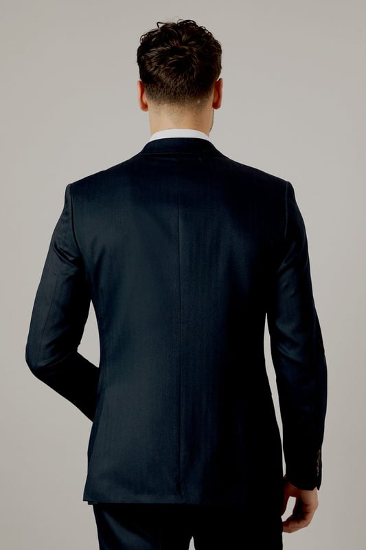 Tailored fit for a refined silhouette
        Distinctive herringbone pattern adds texture
        Notched lapels for classic sophistication
        Two-button front closure for versatile styling
        Flap pockets and a chest welt pocket for functionality
    
    This Burton herringbone suit jacket is the epitome of smart, sophisticated style. The tailored fit sculpts your silhouette while offering ease of movement, perfect for the modern gent who appreciates classic design with a contemporary edge. Ideal for a range of occasions, from important business meetings to smart-casual events at the local pub. Pair with matching trousers and a crisp white shirt for a complete look, or dress it down with dark denim and a light jumper for a more relaxed ensemble. The versatile nature of this jacket makes it a staple for any wardrobe, easily transitioning from day to night. Whether you're heading to the office, attending a wedding, or meeting friends for a posh night out, this jacket will ensure you look polished and put-together.