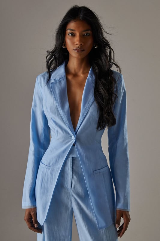Deconstructed organza design for a modern, avant-garde look
        Open back detail adds a daring and feminine touch
        Boxy fit offers a contemporary silhouette
        Versatile piece suitable for both formal and creative occasions
        Lightweight fabric ideal for layering or wearing as a statement piece
    
    Make a bold fashion statement with this deconstructed organza open back blazer from Warehouse. The boxy fit and innovative design create a striking silhouette that's perfect for the confident, fashion-forward woman. Style this blazer for a variety of occasions, from art gallery openings to sophisticated evening events. For a chic ensemble, pair it with the matching wide-leg trousers and metallic pointed-toe heels as seen on the model. Layer over a sleek bodysuit or camisole to balance the sheer elements. This blazer can also be dressed down for more casual settings by teaming it with high-waisted jeans and strappy sandals. The open back detail adds an unexpected twist to the classic blazer form, ensuring you'll turn heads wherever you go. Embrace the edgy and sexy aesthetic of Warehouse with this unique piece that seamlessly blends femininity with avant-garde design.