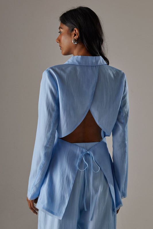 Deconstructed organza design for a modern, avant-garde look
        Open back detail adds a daring and feminine touch
        Boxy fit offers a contemporary silhouette
        Versatile piece suitable for both formal and creative occasions
        Lightweight fabric ideal for layering or wearing as a statement piece
    
    Make a bold fashion statement with this deconstructed organza open back blazer from Warehouse. The boxy fit and innovative design create a striking silhouette that's perfect for the confident, fashion-forward woman. Style this blazer for a variety of occasions, from art gallery openings to sophisticated evening events. For a chic ensemble, pair it with the matching wide-leg trousers and metallic pointed-toe heels as seen on the model. Layer over a sleek bodysuit or camisole to balance the sheer elements. This blazer can also be dressed down for more casual settings by teaming it with high-waisted jeans and strappy sandals. The open back detail adds an unexpected twist to the classic blazer form, ensuring you'll turn heads wherever you go. Embrace the edgy and sexy aesthetic of Warehouse with this unique piece that seamlessly blends femininity with avant-garde design.
