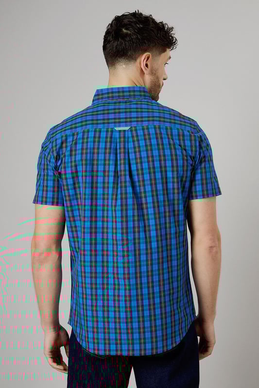 Vibrant tartan check pattern in bright blue tones
        Short sleeve design for warm-weather comfort
        Button-down collar for a smart-casual look
        Woven cotton fabric for breathability
        Versatile fit suitable for various body types
    
    This Maine short sleeve shirt presents a perfect blend of casual charm and smart styling. The eye-catching tartan check pattern in bright blue hues adds a pop of colour to your wardrobe, making it an ideal choice for those seeking to inject some personality into their everyday attire. Whether you're heading to a family barbecue or a casual Friday at the office, this shirt offers versatility in spades. Pair it with dark wash jeans and white trainers for a laid-back look, or dress it up with chinos and loafers for a more polished ensemble. The button-down collar adds a touch of refinement, while the short sleeves keep you cool and comfortable during warmer days. Crafted from woven cotton, this shirt ensures breathability and ease of movement, making it a go-to option for long summer days or relaxed weekend outings. Its adaptable fit flatters various body types, making it a wardrobe staple that you'll reach for time and time again.