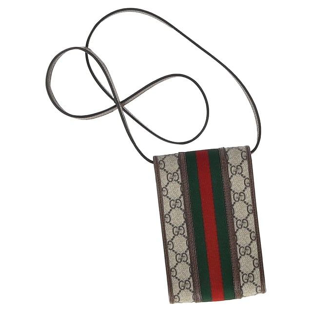 VINTAGE, RRP AS NEW
Elevate your on-the-go style with the Gucci Ophidia Flap Phone Holder Bag in elegant beige coated canvas. Featuring the brand's iconic GG Supreme pattern and the signature green and red Web stripe, this compact yet functional phone holder offers a luxurious way to carry your essentials. Designed with modern convenience in mind, it features a flap closure for easy access to your phone and other small items.

 Gucci Ophidia Flap Phone Holder Bag in Beige Coated Canvas

Condition: Excellent
Signs of wear: No retail tag, No visible sign of wear., 
Packaging: Dust bag
Color: Beige
Material: Canvas | coated/waterproof canvas
Size: One Size | One Size
Measurements: Width: 20; Height: 180; Length: 115; Handle drop: 500; Strap length: 1000
SKU: MRPPUGBBA459666M