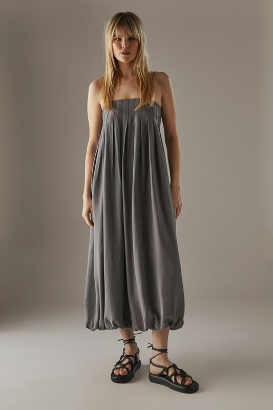 Strappy design with delicate shoulder straps
        Seam detail on bodice creating a pleated effect
        Bubble hem for a playful silhouette
        Midi length for versatile styling
        Relaxed fit through the body for effortless comfort
    
    This strappy seam detail bubble midi sundress from Warehouse is the epitome of casual chic. Perfect for those laid-back summer days, this dress combines comfort with style. The pleated bodice adds texture and interest, while the bubble hem creates a playful, feminine silhouette. Pair it with flat sandals and a woven tote for a relaxed daytime look, or dress it up with wedges and statement earrings for an alfresco dinner. The versatile midi length makes it suitable for various occasions, from family gatherings to casual brunches with friends. Layer with a denim jacket for cooler evenings or style with a wide-brimmed hat for a touch of glamour at outdoor events. This dress is a wardrobe essential that effortlessly transitions from day to night, embodying the confident and edgy spirit of the Warehouse brand.