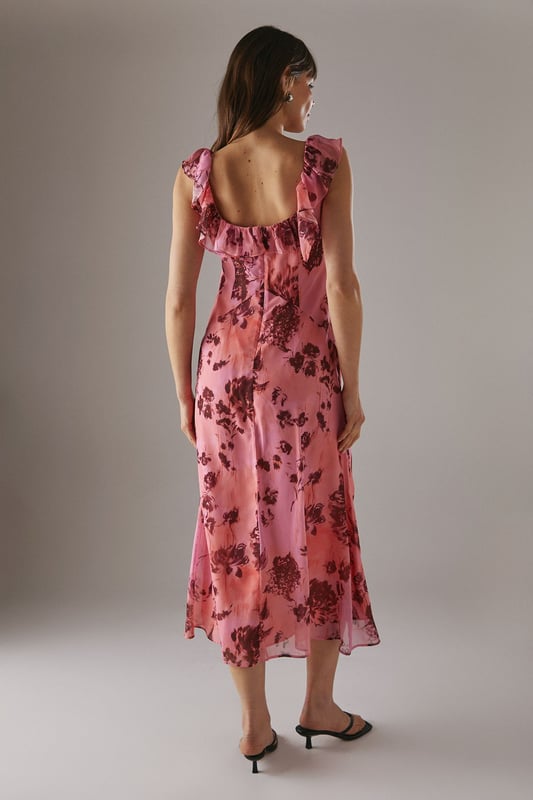 Chiffon fabric with floral print for a light, airy feel
        Double-layered design for added movement and depth
        Ruffle detailing along neckline and shoulders
        Midi length for versatile styling options
        Open back design with delicate ruffle trim
    
    This enchanting midi dress radiates effortless femininity with its flowing chiffon fabric and captivating floral print. The double-layered design adds a touch of sophistication, while the ruffle detailing along the neckline and shoulders creates a romantic silhouette. Perfect for a variety of casual occasions, this dress can be styled with flat sandals for a relaxed daytime look or dressed up with heeled mules for evening gatherings. The open back with ruffle trim adds an unexpected twist, making it an ideal choice for garden parties or summer weddings. Layer with a lightweight cardigan for cooler evenings or pair with statement earrings to enhance its feminine charm. This versatile piece from Warehouse embodies confidence and style, making it a must-have addition to your wardrobe for those moments when you want to feel both comfortable and effortlessly chic.