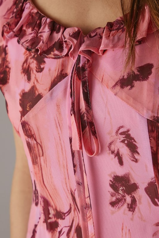 Chiffon fabric with floral print for a light, airy feel
        Double-layered design for added movement and depth
        Ruffle detailing along neckline and shoulders
        Midi length for versatile styling options
        Open back design with delicate ruffle trim
    
    This enchanting midi dress radiates effortless femininity with its flowing chiffon fabric and captivating floral print. The double-layered design adds a touch of sophistication, while the ruffle detailing along the neckline and shoulders creates a romantic silhouette. Perfect for a variety of casual occasions, this dress can be styled with flat sandals for a relaxed daytime look or dressed up with heeled mules for evening gatherings. The open back with ruffle trim adds an unexpected twist, making it an ideal choice for garden parties or summer weddings. Layer with a lightweight cardigan for cooler evenings or pair with statement earrings to enhance its feminine charm. This versatile piece from Warehouse embodies confidence and style, making it a must-have addition to your wardrobe for those moments when you want to feel both comfortable and effortlessly chic.