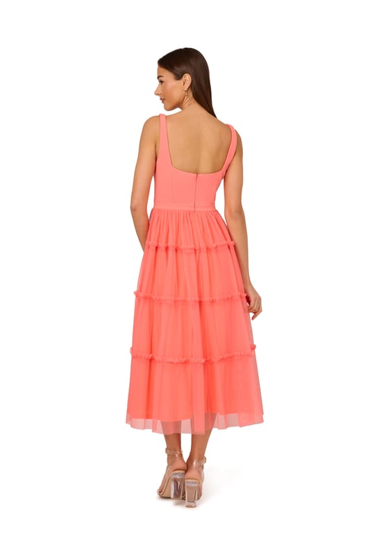 Modern fabric mixes make this classic fit and flare dress a sweet look. This midi dress features a fitted bodice with tank straps, a square neckline, and a tiered skirt. Fully lined, the bodice is crafted from a knit fabrication while the skirt is overlaid in mesh for added sweep. Pockets and a square back with centre zip closure complete this delightful party dress. Styled with nude heels and sparkling accessories, this midi dress is a timeless look from wedding guest duty to cocktail parties