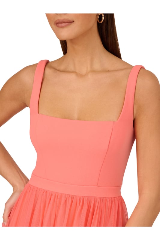 Modern fabric mixes make this classic fit and flare dress a sweet look. This midi dress features a fitted bodice with tank straps, a square neckline, and a tiered skirt. Fully lined, the bodice is crafted from a knit fabrication while the skirt is overlaid in mesh for added sweep. Pockets and a square back with centre zip closure complete this delightful party dress. Styled with nude heels and sparkling accessories, this midi dress is a timeless look from wedding guest duty to cocktail parties