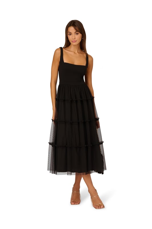 Modern fabric mixes make this classic fit and flare dress a sweet look. This midi dress features a fitted bodice with tank straps, a square neckline, and a tiered skirt. Fully lined, the bodice is crafted from a knit fabrication while the skirt is overlaid in mesh for added sweep. Pockets and a square back with centre zip closure complete this delightful party dress. Styled with nude heels and sparkling accessories, this midi dress is a timeless look from wedding guest duty to cocktail parties