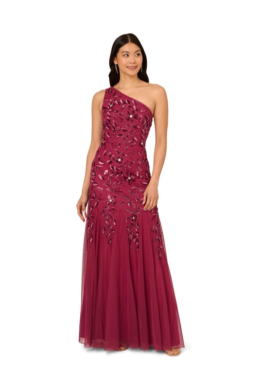 Brighten every ball room you step into in this one shoulder mermaid gown. This formal dress features a fitted bodice, one shoulder neckline, and a mermaid skirt with godet pleats. Crafted from knit mesh that is adorned with stunning sequin beaded florals and the edges are trimmed with lines of tight beading that fades mid-skirt. A hidden zipper closure at the centre back completes this black-tie dress.