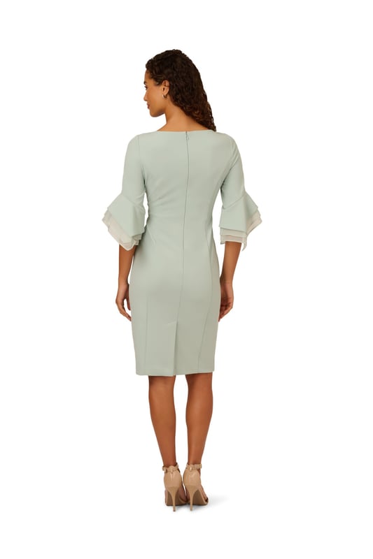 Dressed up meets versatile in this timeless sheath dress. This midi dress features a boat neckline, fitted silhouette through the body, and tiered three-quarter bell sleeves with organza accents. Crafted using knit crepe, this day dress has some stretch and no waist seam for a comfortable fit. A zipper back closure and a single pleat at the centre back of the skirt hem completes the design.