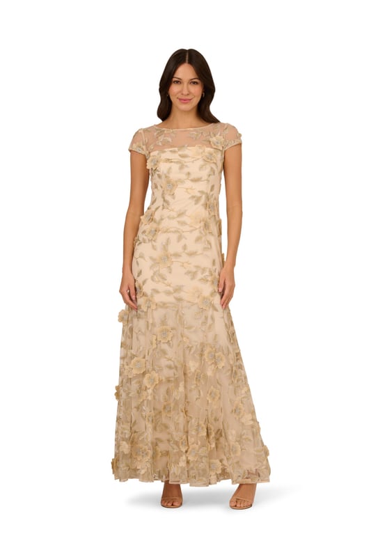 Evoke timeless elegance with this romantic cap sleeve gown. The sheer illusion neckline adds soft sophistication to this mermaid silhouette design. A back zipper closure ensures a fitted look through the bodice while the godet construction adds movement to the skirt. With a floral embroidered overlay finished in dimensional flower accents, this gown will make you feel like a work of art.