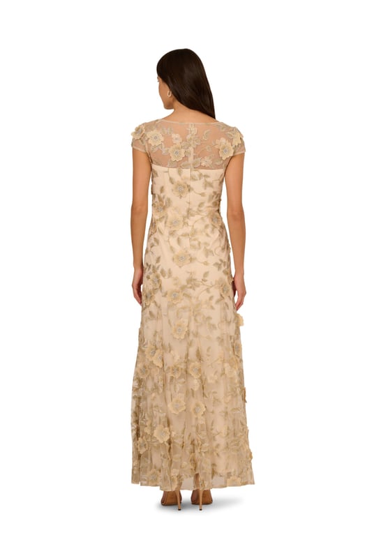 Evoke timeless elegance with this romantic cap sleeve gown. The sheer illusion neckline adds soft sophistication to this mermaid silhouette design. A back zipper closure ensures a fitted look through the bodice while the godet construction adds movement to the skirt. With a floral embroidered overlay finished in dimensional flower accents, this gown will make you feel like a work of art.