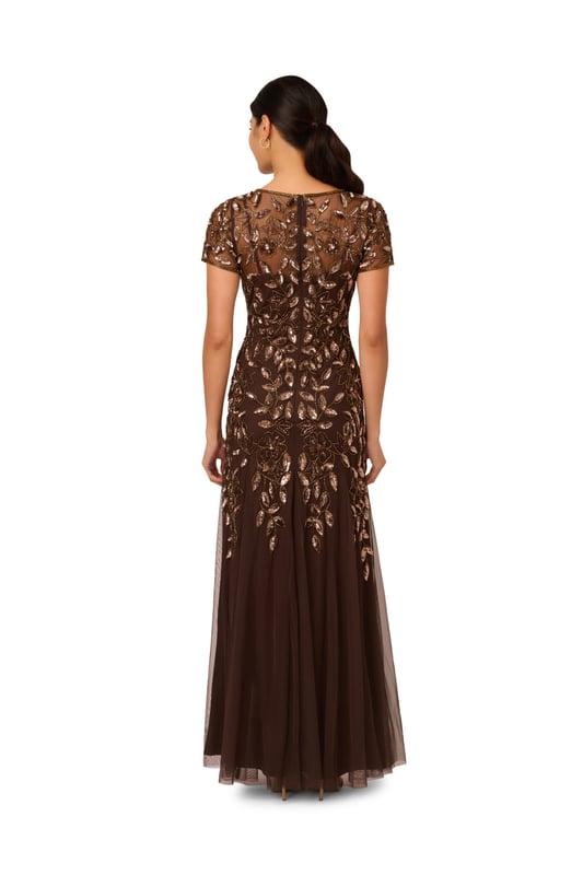 Our long and romantic gown dazzles with all-over handsewn beading in a feminine floral pattern that catches the light with every twirl. A streamlined silhouette is eased with the mermaid skirt with godets to create the right amount of movement. Our iconic and flattering no waist seam, sheer illusion yoke and cap sleeves. Sleek back zip closure.