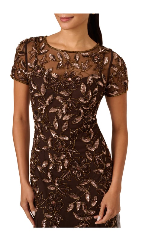 Our long and romantic gown dazzles with all-over handsewn beading in a feminine floral pattern that catches the light with every twirl. A streamlined silhouette is eased with the mermaid skirt with godets to create the right amount of movement. Our iconic and flattering no waist seam, sheer illusion yoke and cap sleeves. Sleek back zip closure.