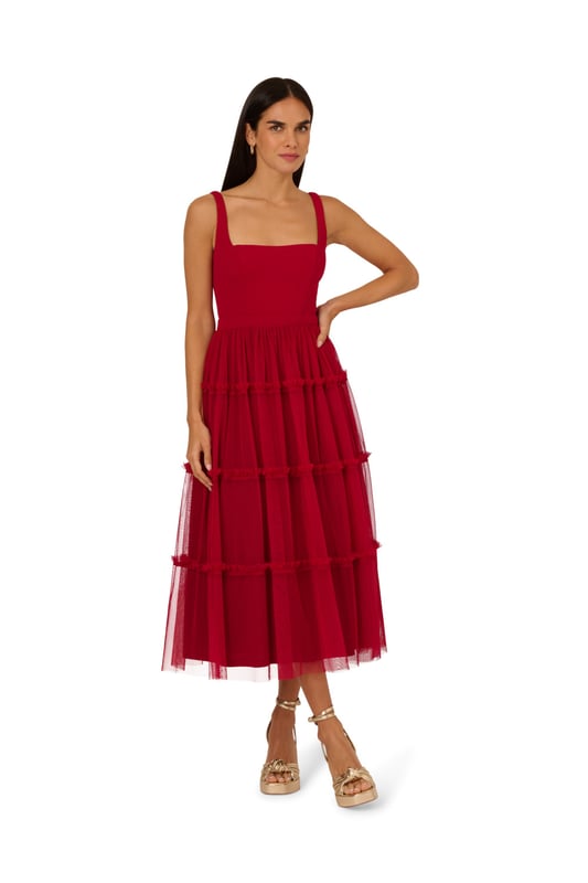 Modern fabric mixes make this classic fit and flare dress a sweet look. This midi dress features a fitted bodice with tank straps, a square neckline, and a tiered skirt. Fully lined, the bodice is crafted from a knit fabrication while the skirt is overlaid in mesh for added sweep. Pockets and a square back with centre zip closure complete this delightful party dress. Styled with nude heels and sparkling accessories, this midi dress is a timeless look from wedding guest duty to cocktail parties