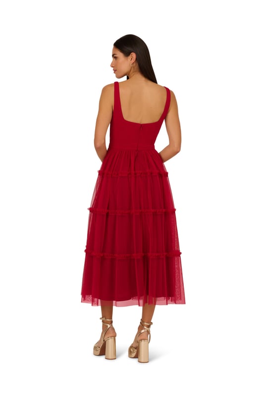 Modern fabric mixes make this classic fit and flare dress a sweet look. This midi dress features a fitted bodice with tank straps, a square neckline, and a tiered skirt. Fully lined, the bodice is crafted from a knit fabrication while the skirt is overlaid in mesh for added sweep. Pockets and a square back with centre zip closure complete this delightful party dress. Styled with nude heels and sparkling accessories, this midi dress is a timeless look from wedding guest duty to cocktail parties