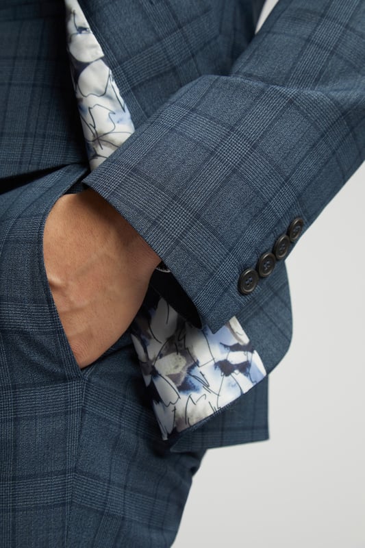 A classic recapture of British tailoring - Alexandre of England present the Blue Soft Check tailored fit suit jacket. Made in a luxurious wool blend with added stretch, for guaranteed comfort and style for any occasion.With a single-breasted, two button fastening, this jacket also features notch lapels, 2 straight flap pockets and tonal printed lining for added impact.