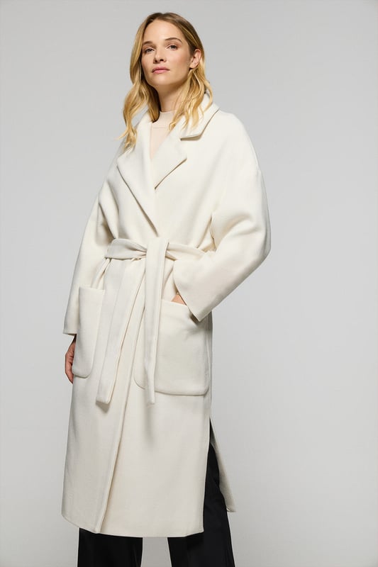 Unser Damenmantel Carrie ist ideal für alle, die ein vielseitiges und stilvolles Kleidungsstück suchen. Das Oversized-Design mit spitzem Reverskragen und langen Ärmeln schafft eine entspannte Silhouette. Der abnehmbare Gürtel ermöglicht es Ihnen, den Mantel an Ihren gewünschten Stil anzupassen, während die beiden Vordertaschen praktischen Stauraum bieten. Die beiden Seitenschlitze sorgen für Bewegungsfreiheit. Das Polo Club Logo auf der Passe unterstreicht den exklusiven Charakter des Mantels. Perfekt für den Alltag oder besondere Anlässe.