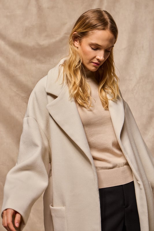 Unser Damenmantel Carrie ist ideal für alle, die ein vielseitiges und stilvolles Kleidungsstück suchen. Das Oversized-Design mit spitzem Reverskragen und langen Ärmeln schafft eine entspannte Silhouette. Der abnehmbare Gürtel ermöglicht es Ihnen, den Mantel an Ihren gewünschten Stil anzupassen, während die beiden Vordertaschen praktischen Stauraum bieten. Die beiden Seitenschlitze sorgen für Bewegungsfreiheit. Das Polo Club Logo auf der Passe unterstreicht den exklusiven Charakter des Mantels. Perfekt für den Alltag oder besondere Anlässe.