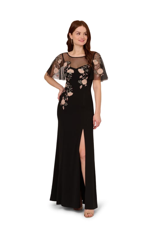 Beaded Crepe Long Dress Lean into formal season with this sweetly beaded gown. This formal dress features a fitted bodice with boat neckline, a sheer yoke that gives a sweetheart neckline illusion, sheer flutter sleeves and a mermaid skirt with thigh-high slit. Crafted from crepe fabric through the body, this dress has knit mesh at the bodice and sleeves that is embellished with beautiful sequin beaded florals. A hidden zipper closure at the sheer v-back completes this black-tie dress. Styled with neutral accessories that let the floral beading shine, this flutter short sleeve gown is a romantic look.