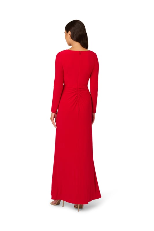 Slinky jersey fabric gives this long sleeve gown dramatic drape and exceptional comfort. A faux wrap construction gives the long dress design dynamic lines across the bodice and down the front of the flowing skirt. The back closes with a zipper and finishes with flattering ruching at the centre hip.