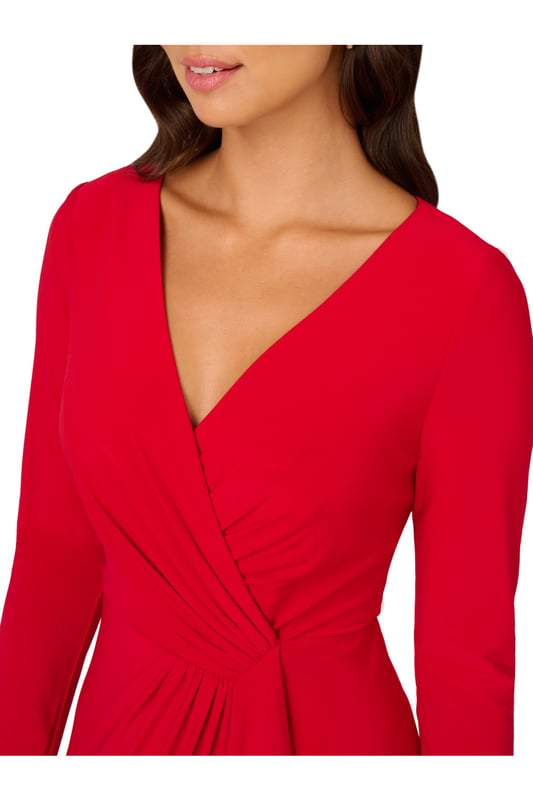 Slinky jersey fabric gives this long sleeve gown dramatic drape and exceptional comfort. A faux wrap construction gives the long dress design dynamic lines across the bodice and down the front of the flowing skirt. The back closes with a zipper and finishes with flattering ruching at the centre hip.