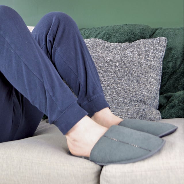 Relax your feet in these super soft and lightly cushioned mule slippers for men. Whether you're working from home, or lounging around indoors, these mule slippers are soft to the touch! Why not treat a loved one, or yourself, to these comfortable and warm mule slippers? They feature a light cushioned sole to help alleviate any pressure and fatigued feeling you may experience in your heels. The insole has a chequered pattern for a trendy look which will match any pair of socks and casual lounge wear! Made from indoor use, these mule slippers have a non-slip hard wearing sole to prevent any slipping or sliding on tiled or wooden flooring. If you're looking to make a fashion statement, these slippers feature a trim on top and around the slipper. With a convenient hands-free slip-on style, these slippers have a spacious opening back design, making them easy to slip on and off. These slippers are available in colours Navy and Grey. They come in mens sizes 7-12 UK, 41-46 EU, 8-13 US.