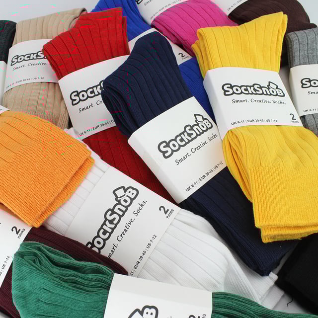 Men’s Plain Coloured Cotton Rich Ribbed Dress Socks: Elevate your everyday style with our Men’s Plain Coloured Cotton Rich Ribbed Dress Socks – a vibrant and comfortable addition to your sock collection. Proudly presented by Sock Snob, these socks bring a burst of colour and unparalleled softness to your wardrobe. Made with soft touch cotton, these socks provide year-round comfort. Experience warmth in the winter and temperature regulation in the summer, thanks to the breathable nature of cotton. The ribbed leg design enhances both comfort and a secure fit, making these socks an excellent choice for any occasion. Dive into our extensive range of over 15 colours, meticulously crafted for fashion-conscious individuals who appreciate variety in their attire. With options like Black, Navy, Royal Blue, Red, Yellow, Orange, Fuschia and more you can add a pop of colour to your daily ensemble. These socks are made from 84% Cotton, 14% Polyamide, and 2% Elastane. They come in 15 colour options which include: Black, Navy, Light Grey, Brown, Beige, Charcoal, Royal Blue, White, Burgundy, Fuschia, Purple, Dark Green, Red, Yellow & Orange. Available in Men’s One Size 6-11 UK they are also Machine Washable. Extra Product Details: Men’s Coloured Dress Socks 6 Pair Pack 15 Colour Options Great For All Occasions Cotton Rich Fibres Soft Grip Top Ribbed Leg Super Comfortable Simple & Practical