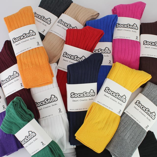 Men’s Plain Coloured Cotton Rich Ribbed Dress Socks: Elevate your everyday style with our Men’s Plain Coloured Cotton Rich Ribbed Dress Socks – a vibrant and comfortable addition to your sock collection. Proudly presented by Sock Snob, these socks bring a burst of colour and unparalleled softness to your wardrobe. Made with soft touch cotton, these socks provide year-round comfort. Experience warmth in the winter and temperature regulation in the summer, thanks to the breathable nature of cotton. The ribbed leg design enhances both comfort and a secure fit, making these socks an excellent choice for any occasion. Dive into our extensive range of over 15 colours, meticulously crafted for fashion-conscious individuals who appreciate variety in their attire. With options like Black, Navy, Royal Blue, Red, Yellow, Orange, Fuschia and more you can add a pop of colour to your daily ensemble. These socks are made from 84% Cotton, 14% Polyamide, and 2% Elastane. They come in 15 colour options which include: Black, Navy, Light Grey, Brown, Beige, Charcoal, Royal Blue, White, Burgundy, Fuschia, Purple, Dark Green, Red, Yellow & Orange. Available in Men’s One Size 6-11 UK they are also Machine Washable. Extra Product Details: Men’s Coloured Dress Socks 6 Pair Pack 15 Colour Options Great For All Occasions Cotton Rich Fibres Soft Grip Top Ribbed Leg Super Comfortable Simple & Practical