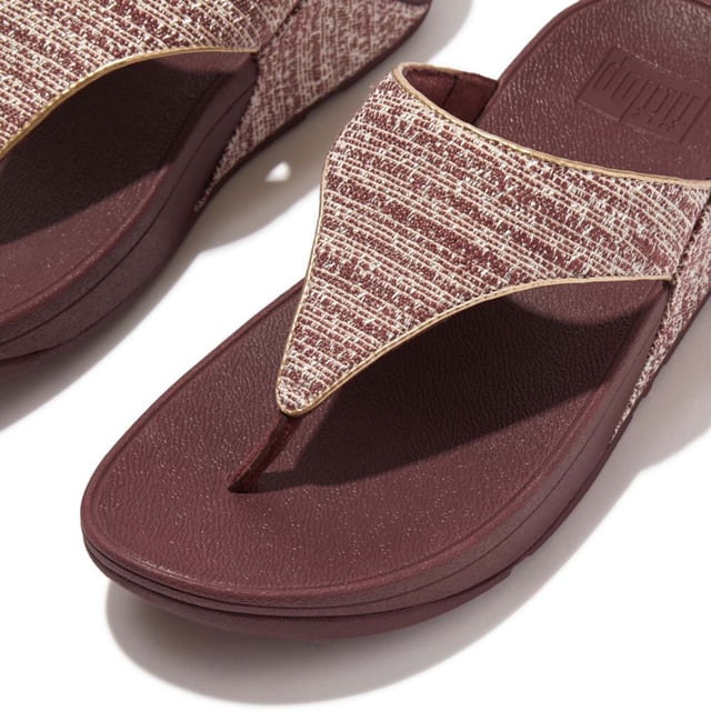 Women's Fit Flop Lulu Shimmerweave Toe-Post Sandals in Brown FitFlop's bestselling Lulu sandals boast a timeless triangular vamp softly padded uppers and a soft microfibre toe post. Featuring FitFlop's Microwobbleboard™ midsoles for unbeatable comfort. This season in a sparkling finely ribbed glitz mesh (with metallic pearlised faux-leather side panels for extra lustre). Beautiful. Versatile. The sophisticated shimmer means these work with multiple looks - dress yours up or down wear day through to night.Ergonomically engineered to help optimize your body's alignment natural movement & energyLight pressure-diffusing Microwobbleboard midsole - triple-density cushioning follows 3 footstep stages (firm heel-soft middle-medium at toes)Natural arch supportAverage to wide fitGrip level 1 - everyday use-road treadThese shoes have been granted the APMA* Seal of Acceptance for footwear found to promote good foot health*American Podiatric Medical Association