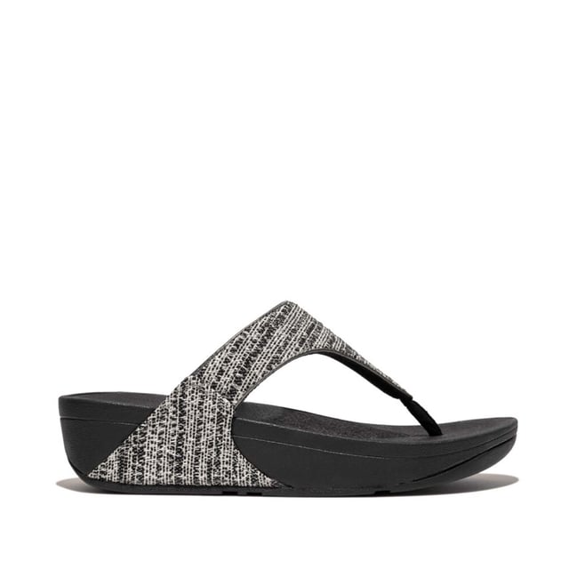 Women's Fit Flop Lulu Shimmerweave Toe-Post Sandals in Black FitFlop's bestselling Lulu sandals boast a timeless triangular vamp softly padded uppers and a soft microfibre toe post. Featuring FitFlop's Microwobbleboard™ midsoles for unbeatable comfort. This season in a sparkling finely ribbed glitz mesh (with metallic pearlised faux-leather side panels for extra lustre). Beautiful. Versatile. The sophisticated shimmer means these work with multiple looks - dress yours up or down wear day through to night.Ergonomically engineered to help optimize your body's alignment natural movement & energyLight pressure-diffusing Microwobbleboard midsole - triple-density cushioning follows 3 footstep stages (firm heel-soft middle-medium at toes)Natural arch supportAverage to wide fitGrip level 1 - everyday use-road treadThese shoes have been granted the APMA* Seal of Acceptance for footwear found to promote good foot health*American Podiatric Medical Association