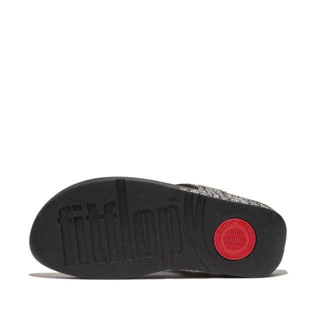 Women's Fit Flop Lulu Shimmerweave Toe-Post Sandals in Black FitFlop's bestselling Lulu sandals boast a timeless triangular vamp softly padded uppers and a soft microfibre toe post. Featuring FitFlop's Microwobbleboard™ midsoles for unbeatable comfort. This season in a sparkling finely ribbed glitz mesh (with metallic pearlised faux-leather side panels for extra lustre). Beautiful. Versatile. The sophisticated shimmer means these work with multiple looks - dress yours up or down wear day through to night.Ergonomically engineered to help optimize your body's alignment natural movement & energyLight pressure-diffusing Microwobbleboard midsole - triple-density cushioning follows 3 footstep stages (firm heel-soft middle-medium at toes)Natural arch supportAverage to wide fitGrip level 1 - everyday use-road treadThese shoes have been granted the APMA* Seal of Acceptance for footwear found to promote good foot health*American Podiatric Medical Association
