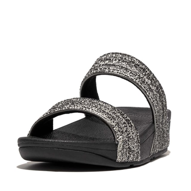 Women's Fit Flop Lulu Shimmerweave Sliders in Black De Lulu slippers van FitFlop zijn klassiekers. Blijvend populair, ze zijn zacht gevoerd en kunnen omhoog of omlaag gekleed worden. Ze staan op FitFlop's legendarische super dempende Microwobbleboard™ tussenzool. Dit seizoen uitgevoerd in een glinsterende structuurstof met een chique 'tweedy' uitstraling. Afgerand met metallic parelmoeren biezen van imitatieleer voor extra glans. Subtiel glinsterende sandalen die je overal bij kunt dragen en prachtig zijn van dag tot nacht.