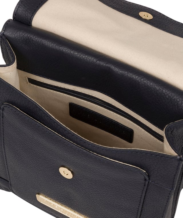 The 'Naomi' cross body bag from Pure Luxuries London is crafted from leather that has a soft pebble grain finish. The fold over top conceals the 100% untreated cotton lined compartment which is complemented by pockets on the interior and exterior of the bag, providing organised storage for all of your essentials. Comes with an adjustable and matching leather strap to suit your needs. Adorned with eye-catching gold coloured fittings and finished with the Pure Luxuries London charm and logo.
