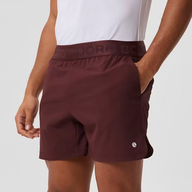 Ace Short Shorts - Sleek and Functional Activewear: Enhance your workout with the Björn Borg Ace Short Shorts, designed for maximum movement and comfort. Made from soft recycled polyester with a hint of stretch, these shorts feature a regular fit with a shorter length, side pockets with a key pocket, and slits on the sides for added mobility. The classic elastic waistband includes a drawstring for easy adjustment, complemented by the iconic tennis-ball logo on the leg. Extra Product Details:. 92% Recycled Polyester, 8% elastane Regular Fit and Short Length Side Pockets with Key Pocket Slits for Extra Movement Machine Washable. These shorts combine sustainability with performance, making them ideal for any sport or workout.