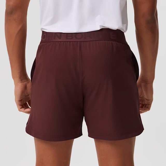 Ace Short Shorts - Sleek and Functional Activewear: Enhance your workout with the Björn Borg Ace Short Shorts, designed for maximum movement and comfort. Made from soft recycled polyester with a hint of stretch, these shorts feature a regular fit with a shorter length, side pockets with a key pocket, and slits on the sides for added mobility. The classic elastic waistband includes a drawstring for easy adjustment, complemented by the iconic tennis-ball logo on the leg. Extra Product Details:. 92% Recycled Polyester, 8% elastane Regular Fit and Short Length Side Pockets with Key Pocket Slits for Extra Movement Machine Washable. These shorts combine sustainability with performance, making them ideal for any sport or workout.