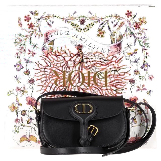 VINTAGE, RRP AS NEW
Timeless elegance in a compact design, the Dior New Dior Bobby Mini Bag in Black Calfskin Leather is a refined take on the classic hobo silhouette. Crafted from luxurious black box calfskin, this mini bag boasts the sophisticated lines and harmonious proportions that define Dior’s iconic style. The antique gold-finish metal details add a vintage charm, while the magnetic clasp with the decorative CD buckle exudes the House’s signature refinement. With a removable and adjustable leather shoulder strap featuring elegant pin buckles, the bag offers versatile styling options – carry it by hand, wear it over your shoulder, or style it crossbody for a laid-back, chic look. Inside, the calfskin and goatskin lining along with an interior slip pocket ensure both beauty and functionality. Whether you're dressing up for an evening out or adding a luxury touch to your day-to-day look, the Dior Bobby Mini Bag is the ultimate accessory for every occasion.



with Box, Dust bag

Dior New Dior Bobby Mini Bag in Black Calfskin Leather
vCondition: Excellent
Signs of wear: No retail tag, No visible sign of wear., 
Packaging: Box, Dust bag
Color: black
Material: Leather | leather
Size: One Size | One Size
Measurements: Width: 170; Height: 100; Length: 170; Handle drop: 0; Strap length: 580
SKU: NAPPUGBBA458696W