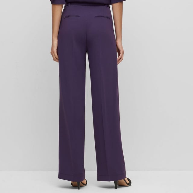 Dames BOSS Tapiana relaxed-fit broek van kreukherstellende Japanse crêpe in paars.Chique kreukherstellende broek van Japanse crêpe van BOSS Womenswear. Deze broek met wijde pijpen en riem heeft een relaxte pasvorm en een plooi aan de voorkant. Dit product is gemaakt met cellulosevezels die afkomstig zijn van natuurlijk ruw houtmateriaal en afkomstig zijn uit verantwoord beheerde bossen.- Gulp met rits en knoopsluiting.- Inclusief riem.- Hoge taille.- Wijde pijpen.- Plooi aan de voorkant.- Franse zakken aan de voorkant; paspelzak aan de achterkant.- Relaxed fit.- Kwaliteit: 69% Triacetaat 31% Polyester. Zakken: 100% Katoen.  Machinewasbaar.- Ref: 50479405-506