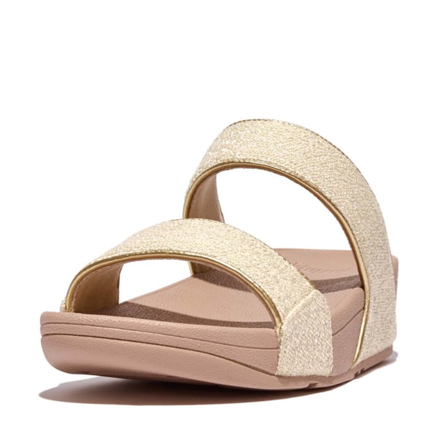 Women's Fit Flop Lulu Shimmerweave Sliders in Stone De Lulu slippers van FitFlop zijn klassiekers. Blijvend populair, ze zijn zacht gevoerd en kunnen omhoog of omlaag gekleed worden. Ze staan op FitFlop's legendarische super dempende Microwobbleboard™ tussenzool. Dit seizoen uitgevoerd in een glinsterende stof met een chique 'tweedy' uitstraling. Afgerand met metallic parelmoeren biezen van imitatieleer voor extra glans. Subtiel glinsterende sandalen die je overal bij kunt dragen en prachtig zijn van dag tot nacht.