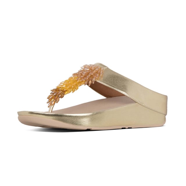 Doe de Rumba...met deze glinsterende, sierlijke teenslippers. Het slanke bovenwerk is bezaaid met een glanzende zwierige franje van veelkleurige 'kristallen' kralen (helder gekleurd en metallic). Op FitFlop's legendarische Microwobbleboard™ tussenzolen voor onovertroffen comfort en demping, de hele dag door. Trek ze aan en ga op zoek naar een feestje! Hier in zacht metallic kunstleer.