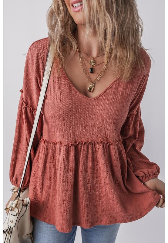 Blusa de color sólido en rojo mineral  
Tejido texturizado para mayor profundidad  
Detalle de volantes en los bordes  
Escote en V para un aspecto elegante  
Mangas abullonadas para una silueta dramática  
Diseño versátil y atemporal  
Material: 85% Poliéster 10% Algodón 5% Elastano