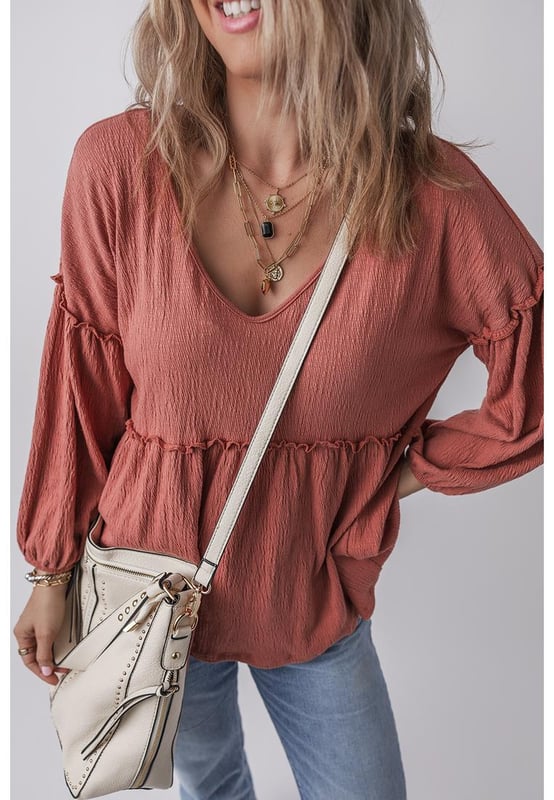 Blusa de color sólido en rojo mineral  
Tejido texturizado para mayor profundidad  
Detalle de volantes en los bordes  
Escote en V para un aspecto elegante  
Mangas abullonadas para una silueta dramática  
Diseño versátil y atemporal  
Material: 85% Poliéster 10% Algodón 5% Elastano