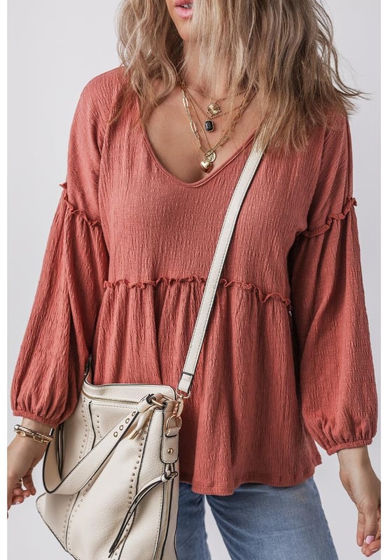 Blusa de color sólido en rojo mineral  
Tejido texturizado para mayor profundidad  
Detalle de volantes en los bordes  
Escote en V para un aspecto elegante  
Mangas abullonadas para una silueta dramática  
Diseño versátil y atemporal  
Material: 85% Poliéster 10% Algodón 5% Elastano
