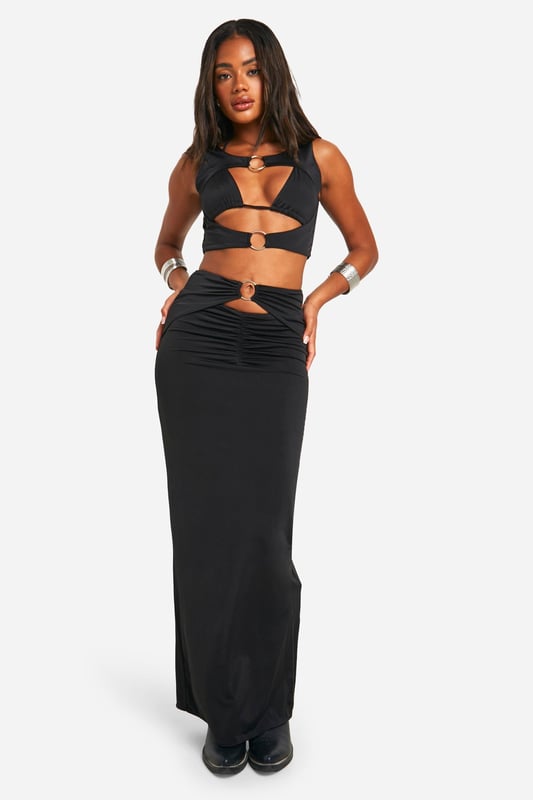 Daring cut-out design with O-ring details
        Floor-sweeping maxi length for dramatic flair
        Figure-hugging silhouette accentuates curves
        Ruched detailing at the waist for added texture
        Versatile piece suitable for various evening events
    
    Make a bold statement at your next festival or night out with this eye-catching cut-out maxiskirt. The daring design features strategically placed O-ring details that add an edgy touch to your ensemble. The figure-hugging silhouette and floor-sweeping length create a striking look that's sure to turn heads. Style it with a cropped top and chunky boots for a festival-ready outfit, or pair it with strappy heels and statement jewellery for a night on the town. The ruched detailing at the waist adds texture and interest, while also flattering your figure. This versatile piece can be dressed up or down, making it a must-have addition to your wardrobe for various evening occasions. Whether you're dancing the night away or enjoying drinks with friends, this maxiskirt will help you project confidence and style.