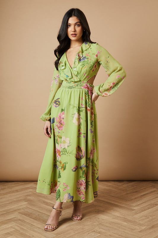 Enchanting floral print midi dress
        Flattering V-neckline with ruffle detail
        Long sleeves with elegant cuffs
        Cinched waist with matching fabric belt
        Stylish cut-out detail at the back
    
    Embrace the essence of feminine charm with this captivating printed midi dress from Oasis. The flowing chiffon fabric creates a graceful silhouette, while the vibrant floral pattern adds a touch of whimsy to your ensemble. Perfect for daytime events, this versatile piece can be styled for various casual occasions. Pair it with strappy sandals and a woven bag for a relaxed garden party look, or dress it down with white trainers and a denim jacket for a leisurely weekend brunch. The cut-out detail at the back adds a subtle hint of allure, making this dress a standout choice for family gatherings or afternoon tea with friends. Accessorise with delicate gold jewellery to complement the dress's romantic appeal and create a look that's both effortless and sophisticated.