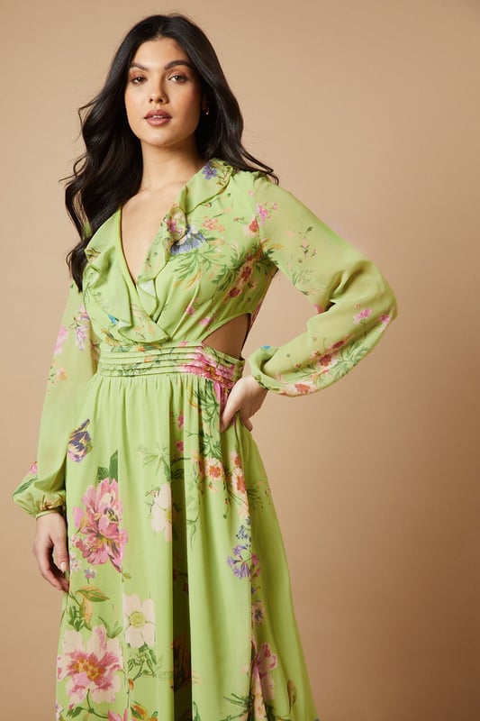 Enchanting floral print midi dress
        Flattering V-neckline with ruffle detail
        Long sleeves with elegant cuffs
        Cinched waist with matching fabric belt
        Stylish cut-out detail at the back
    
    Embrace the essence of feminine charm with this captivating printed midi dress from Oasis. The flowing chiffon fabric creates a graceful silhouette, while the vibrant floral pattern adds a touch of whimsy to your ensemble. Perfect for daytime events, this versatile piece can be styled for various casual occasions. Pair it with strappy sandals and a woven bag for a relaxed garden party look, or dress it down with white trainers and a denim jacket for a leisurely weekend brunch. The cut-out detail at the back adds a subtle hint of allure, making this dress a standout choice for family gatherings or afternoon tea with friends. Accessorise with delicate gold jewellery to complement the dress's romantic appeal and create a look that's both effortless and sophisticated.