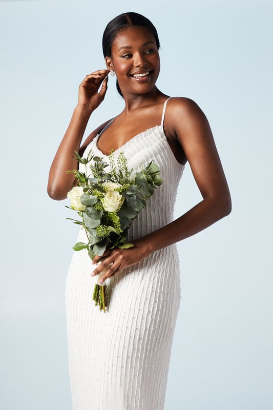 Elegant cowl neck design with intricate beading and pearl embellishments
        Figure-flattering column silhouette for a sleek and sophisticated look
        Delicate spaghetti straps offer a graceful and feminine touch
        Hand-stitched detailing showcases exquisite craftsmanship
        Midi length with a subtle back slit for ease of movement
    
    Make a stunning entrance on your special day with this captivating bridal midi dress from Coast. The cowl neck drapes beautifully, creating an alluring neckline that draws the eye. The column silhouette elongates your figure, whilst the beading and pearl embellishments add a touch of glamour and sparkle. Perfect for the modern bride who desires a blend of classic elegance and contemporary style. Pair with strappy heels and delicate drop earrings to complete your bridal ensemble. This versatile piece can also be styled for other formal occasions, such as engagement parties or sophisticated evening events, by adding a tailored blazer and statement clutch. The hand-stitched detailing ensures this dress is a true work of art, worthy of your most cherished moments.