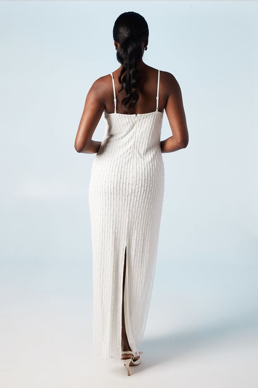 Elegant cowl neck design with intricate beading and pearl embellishments
        Figure-flattering column silhouette for a sleek and sophisticated look
        Delicate spaghetti straps offer a graceful and feminine touch
        Hand-stitched detailing showcases exquisite craftsmanship
        Midi length with a subtle back slit for ease of movement
    
    Make a stunning entrance on your special day with this captivating bridal midi dress from Coast. The cowl neck drapes beautifully, creating an alluring neckline that draws the eye. The column silhouette elongates your figure, whilst the beading and pearl embellishments add a touch of glamour and sparkle. Perfect for the modern bride who desires a blend of classic elegance and contemporary style. Pair with strappy heels and delicate drop earrings to complete your bridal ensemble. This versatile piece can also be styled for other formal occasions, such as engagement parties or sophisticated evening events, by adding a tailored blazer and statement clutch. The hand-stitched detailing ensures this dress is a true work of art, worthy of your most cherished moments.